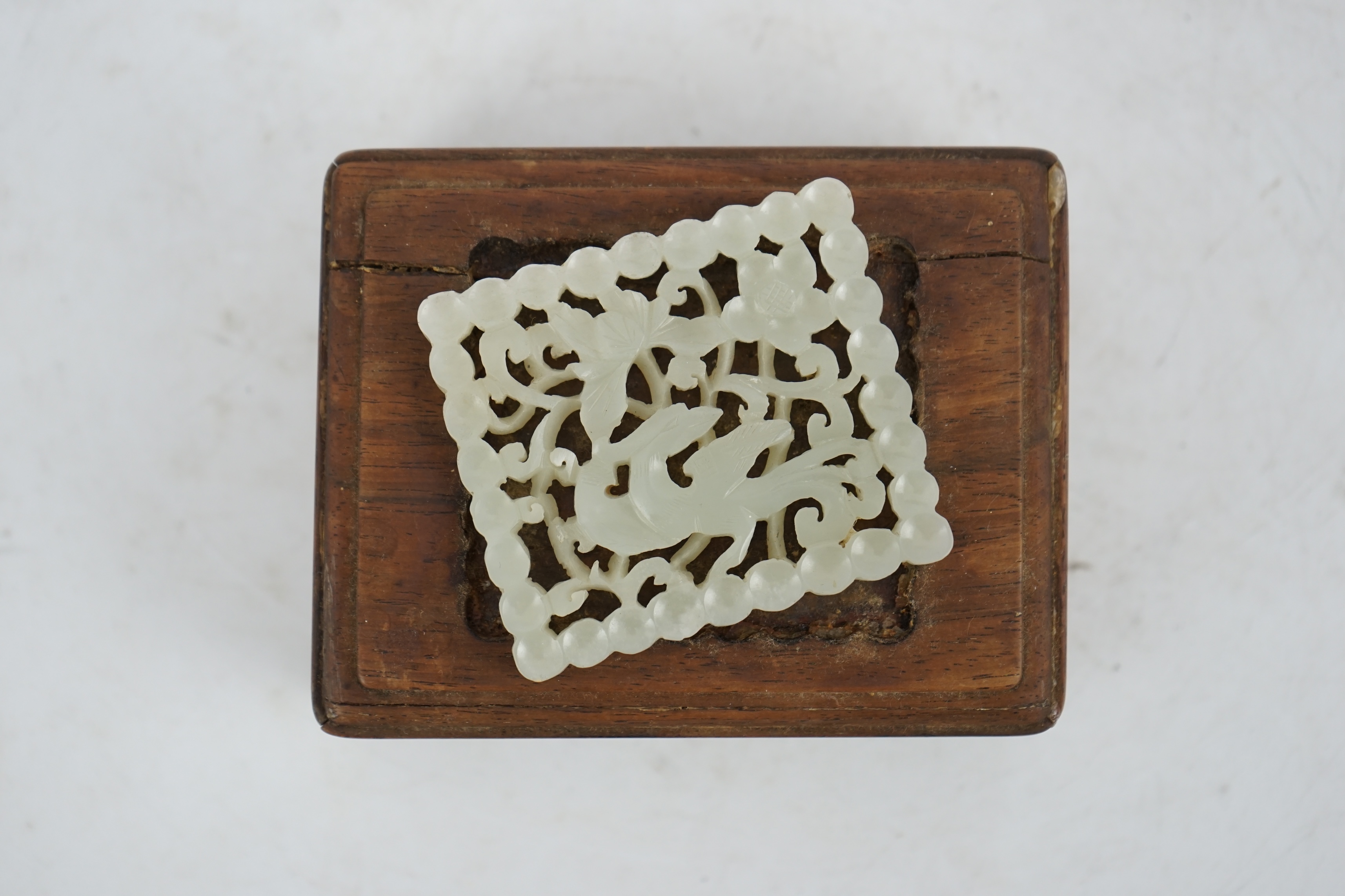 A Chinese pale celadon jade plaque, 17th/18th century, now inset into a hongmu box